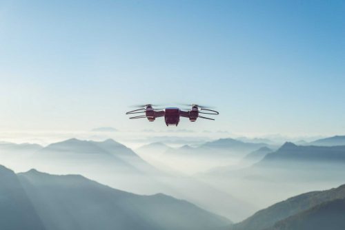 An image of a drone in the sky above a mountain range